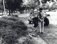 405150 Afbeelding van twee medewerkers van de gemeentelijke plantsoenendienst tijdens het schoonmaken van een plantsoen ...